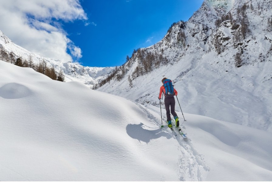 En skimo-utøver på vei oppover fjellterreng